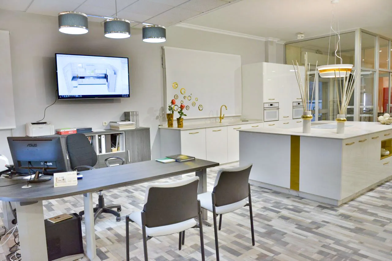 Estudio de diseño de Cocinas Fuoco en Sevilla con mesa de atención al cliente, pantalla de proyectos 3D y cocina de exposición