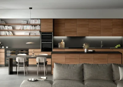 Cocina de madera de roble con isla central, salpicadero de pizarra oscura, frigorífico americano y tiradores negros