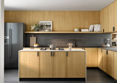 Cocina rústica beige en L con tiradores redondos dorados, horno doble columna, botellero y fregadero bajo ventana