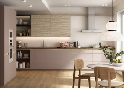 Cocina rosa y madera lineal con muebles altos de roble, encimera oscura, horno blanco columna y campana decorativa