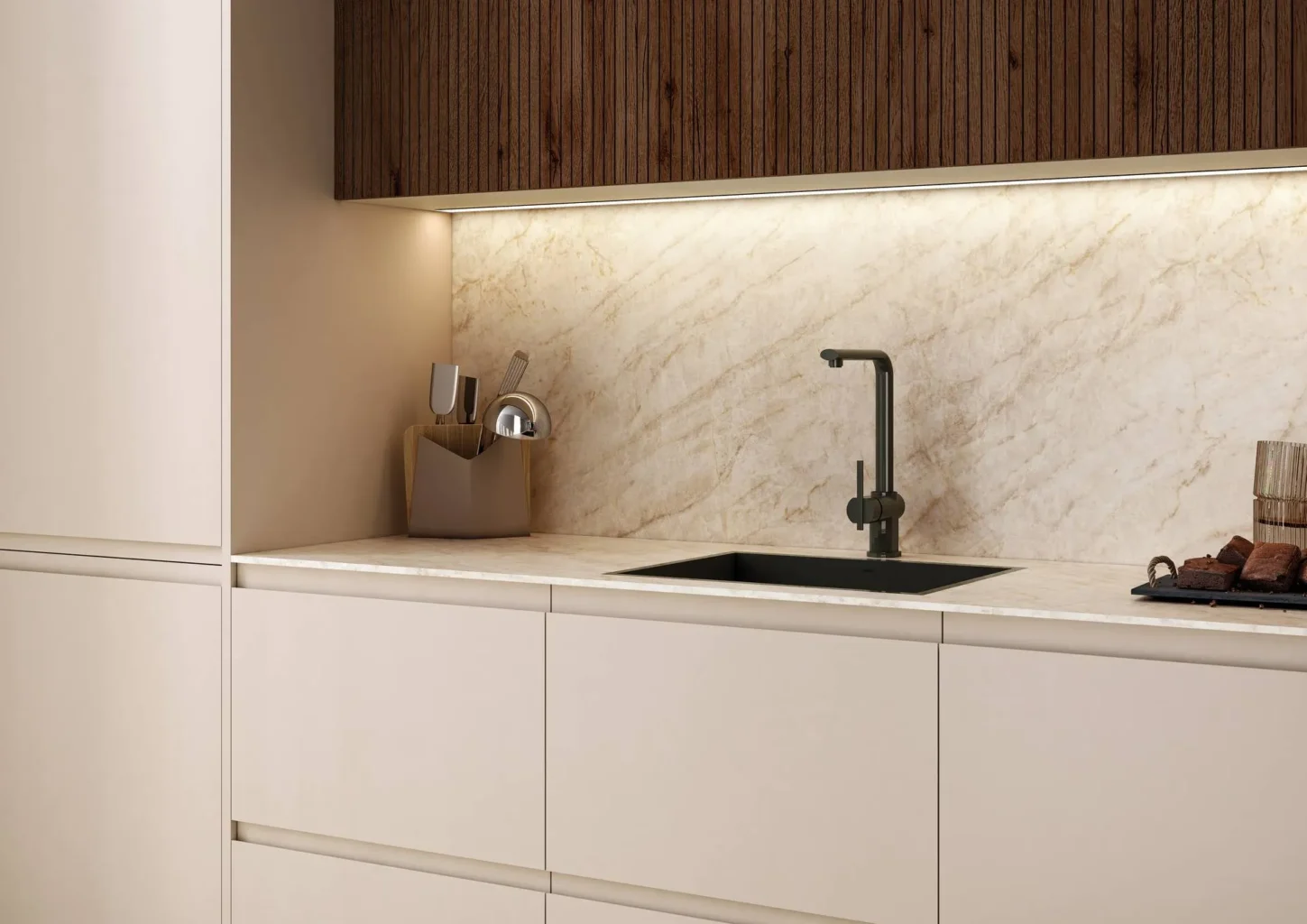 Detalle de zona de fregadero con frentes beige mate, salpicadero de mármol iluminado con LED y grifo negro mate