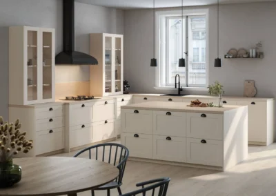 Cocina clásica beige con isla y tiradores negros tipo concha, vitrinas con cristal, campana negra y lámparas colgantes