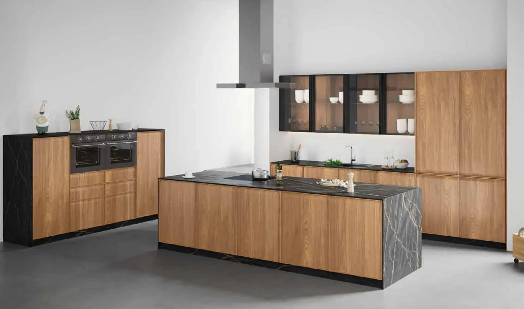 Cocina de madera nogal y gris con isla de mármol blanco, muebles columna con horno doble Siemens y vitrinas iluminadas