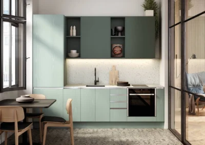 Cocina pequeña verde menta lineal con muebles altos verde oscuro, estantes abiertos, salpicadero de terrazo y cristalera al salón