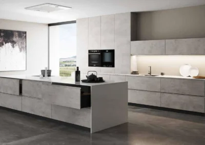Cocina azul navy con isla de mármol blanco y taburetes de madera, columna de madera clara con vitrina de cristal