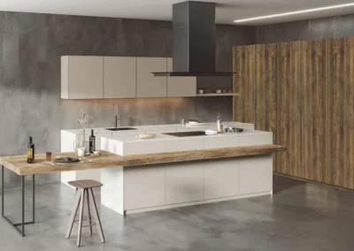 Cocina azul navy con isla de mármol blanco y taburetes, columna de madera nogal con vitrina de cristal y lámparas colgantes